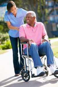 Care worker Pushing Senior Man In Wheelchair