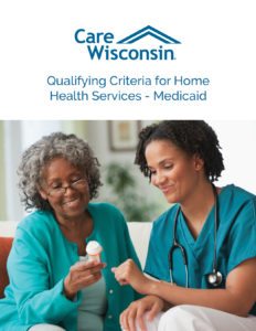 A smiling nurse and smiling elderly woman look at the label of a prescription bottle of pills