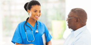 A nurse with a stethoscope smiles at a patient